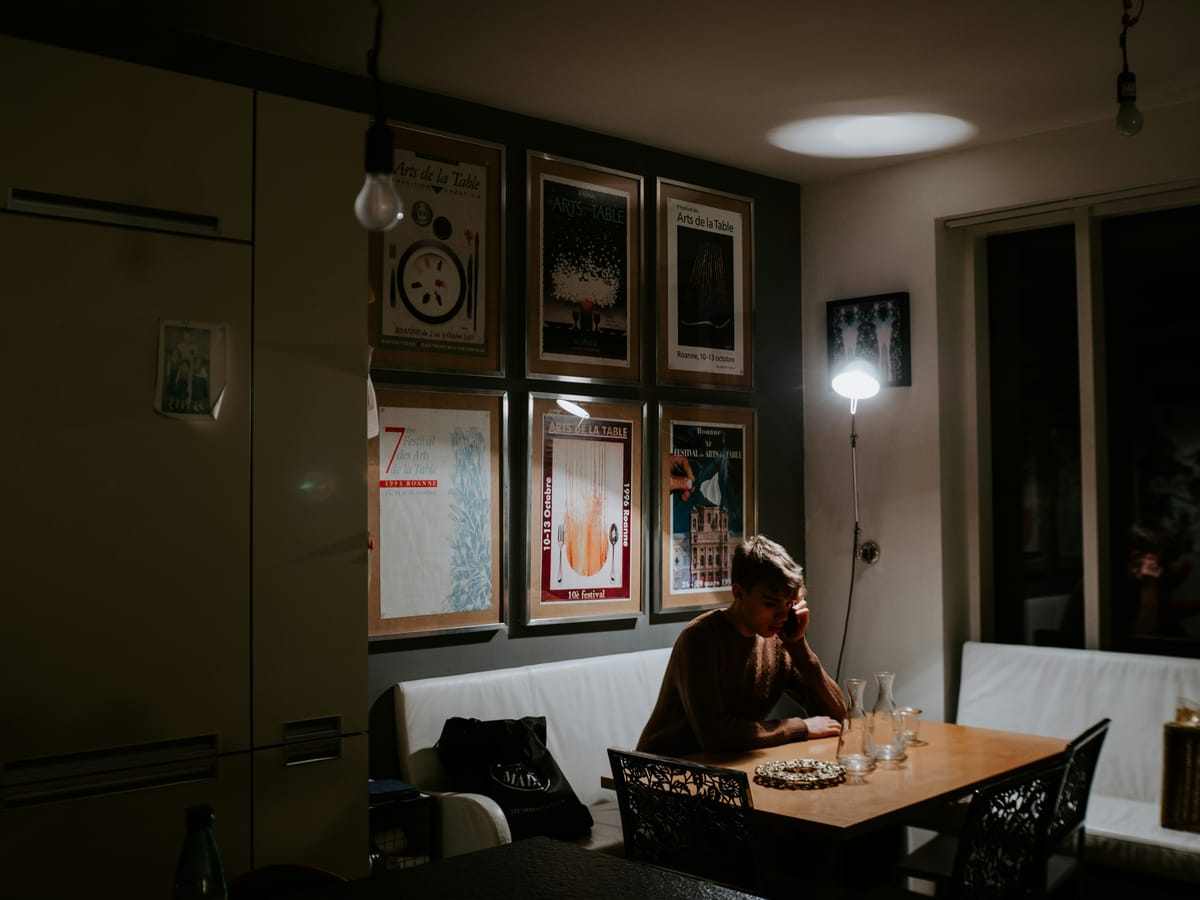 一個人在昏暗燈光下獨自工作，象徵在沒有迴響時仍持續努力