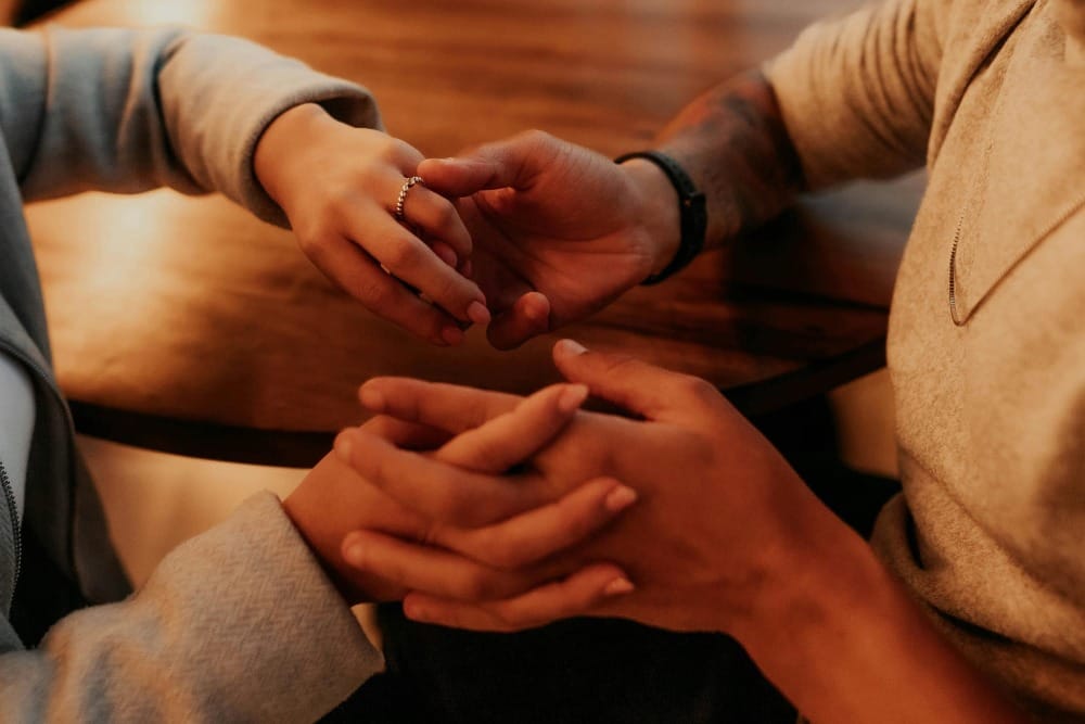 Two people holding hands warmly, representing emotional boundaries, empathy, and caring without losing yourself.